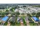 Wide aerial shot of a neighborhood with lush landscaping, a community pond, and a mix of single-Gathering homes at 254 Andalusia Loop, Davenport, FL 33837