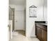 Clean bathroom features a glass-enclosed shower, neutral tile, and a vanity with dark countertops for a modern touch at 254 Andalusia Loop, Davenport, FL 33837