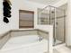 Bright bathroom featuring a soaking tub, separate glass shower, and decorative mosaic tile accents at 254 Andalusia Loop, Davenport, FL 33837
