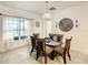 Bright dining room features a glass table, six chairs, pendant lighting, and neutral decor for a serene ambiance at 254 Andalusia Loop, Davenport, FL 33837