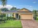 Charming one-story home with a brick driveway, well-maintained landscaping, and attached two-car garage at 254 Andalusia Loop, Davenport, FL 33837