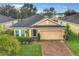 Charming one-story home with a brick driveway, well-maintained landscaping, and an attached two-car garage at 254 Andalusia Loop, Davenport, FL 33837