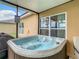 Relax in this inviting hot tub featuring clear water and situated under a covered patio at 254 Andalusia Loop, Davenport, FL 33837
