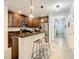 Inviting kitchen featuring dark wood cabinetry, stainless steel appliances, granite countertops, and a breakfast bar at 254 Andalusia Loop, Davenport, FL 33837
