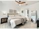 Calm main bedroom boasts soft lighting, wood-look floors, and a glimpse into the attached bathroom for convenience at 254 Andalusia Loop, Davenport, FL 33837