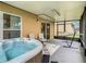 View of the covered patio with seating, a hot tub, and a hammock for relaxation at 254 Andalusia Loop, Davenport, FL 33837