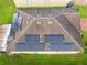 Overhead view of roof with solar panels and shingles, surrounded by green lawn at 254 Andalusia Loop, Davenport, FL 33837