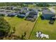 Aerial view of spacious backyard with fire pit and view of the neighborhood, lake, and solar panels at 2613 Camden Park Loop, Davenport, FL 33837