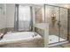 This bathroom features a separate soaking tub and a glass enclosed shower with tile surround at 2613 Camden Park Loop, Davenport, FL 33837