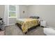 Bright bedroom with a yellow floral comforter and a white nightstand at 2613 Camden Park Loop, Davenport, FL 33837