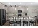 Open kitchen features a large island with seating, modern appliances, and stylish pendant lighting at 2613 Camden Park Loop, Davenport, FL 33837