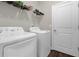 Functional laundry room featuring a washer, dryer, wire shelving, and a door at 2613 Camden Park Loop, Davenport, FL 33837