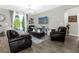 Bright and inviting living room featuring dark leather seating, modern decor, and view of the outdoor patio at 2613 Camden Park Loop, Davenport, FL 33837