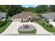 An aerial view of a lovely home showcasing a circular driveway with fountain and lush green landscaping at 26901 Racquet Cir, Leesburg, FL 34748