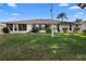 Expansive backyard with lush green grass, mature landscaping, a patio, and a well-maintained lawn at 26901 Racquet Cir, Leesburg, FL 34748