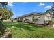 Spacious backyard with lush green grass and mature landscaping surrounding the home at 26901 Racquet Cir, Leesburg, FL 34748