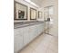 Elegant bathroom featuring a double sink vanity and mirrored closet at 26901 Racquet Cir, Leesburg, FL 34748
