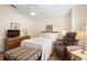 Cozy bedroom with tiled floor, ceiling fan, recliner, and dresser with TV at 26901 Racquet Cir, Leesburg, FL 34748