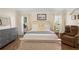 Bright bedroom with neutral walls, white bedding, and comfortable chair at 26901 Racquet Cir, Leesburg, FL 34748