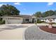 Inviting home featuring a circular driveway, lush landscaping, and an attached two-car garage at 26901 Racquet Cir, Leesburg, FL 34748