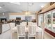 Dining room showcases stylish white furnishings and views of the modern kitchen at 26901 Racquet Cir, Leesburg, FL 34748