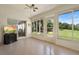 Bright sun room with large windows offering a view of the manicured lawn at 26901 Racquet Cir, Leesburg, FL 34748