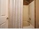 Bathroom featuring a shower and tub combo with tan tile and shower curtain at 297 Sky Valley St, Clermont, FL 34711