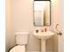 Cozy half bath with pedestal sink and mirror in neutral color palette at 297 Sky Valley St, Clermont, FL 34711