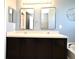 Bathroom featuring dual sinks, modern mirrors, and a decorative starburst accent piece at 297 Sky Valley St, Clermont, FL 34711