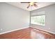 Bedroom featuring hardwood floors, a modern ceiling fan, and a large bright window at 297 Sky Valley St, Clermont, FL 34711