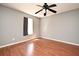 Bedroom featuring hardwood floors, a modern ceiling fan, and a bright window with dark curtains at 297 Sky Valley St, Clermont, FL 34711