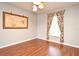 Cozy bedroom featuring hardwood floors, an artistic hanging, and a bright window with decorative curtains at 297 Sky Valley St, Clermont, FL 34711
