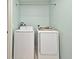 Bright laundry room featuring a full-sized washer and dryer on a tile floor with light blue walls at 297 Sky Valley St, Clermont, FL 34711