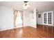 Open living room with hardwood floors, a window with patterned curtains, and access to the entry at 297 Sky Valley St, Clermont, FL 34711
