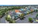 A street view of colorful homes in a neighborhood with parking and lush landscaping. Arrow indicates subject house at 3083 Key Lime Loop, Kissimmee, FL 34747