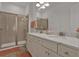 Bathroom featuring double sinks, marble countertops and a walk-in shower at 3083 Key Lime Loop, Kissimmee, FL 34747