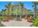Charming colorful home with a cozy fire pit area and Adirondack chairs for outdoor relaxation at 3083 Key Lime Loop, Kissimmee, FL 34747