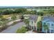 Charming two-story yellow home featuring a balcony, covered porch, and lush tropical landscaping at 3083 Key Lime Loop, Kissimmee, FL 34747