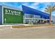 Striking blue movie grill exterior featuring a modern architectural design and lush green accents at 3083 Key Lime Loop, Kissimmee, FL 34747