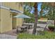 Charming outdoor patio with table, chairs, umbrella, and beautiful landscaping for relaxing or entertaining at 3083 Key Lime Loop, Kissimmee, FL 34747