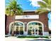 Exterior of SunnySide cafe featuring brick facade, arched windows, and palm trees under a bright blue sky at 3083 Key Lime Loop, Kissimmee, FL 34747