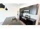 Close-up of kitchen featuring stainless appliances, dark cabinets, and island sink at 3259 Energy Dr, Kissimmee, FL 34747