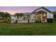 Expansive backyard featuring a manicured lawn, mature palm trees, and a covered outdoor kitchen area at 3382 Fernlake Pl, Longwood, FL 32779