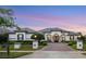 Stately single story home with mature landscaping, brick driveway and a beautiful dusk sky at 3382 Fernlake Pl, Longwood, FL 32779