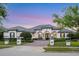 Beautiful single-story home with manicured landscaping, paver driveway, and elegant exterior lighting at 3382 Fernlake Pl, Longwood, FL 32779