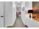 Bright hallway with hardwood floors, leading to a bedroom with red curtains at 3382 Fernlake Pl, Longwood, FL 32779