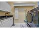 Well-organized laundry room with modern washer and dryer, storage cabinets, and a utility sink at 3382 Fernlake Pl, Longwood, FL 32779