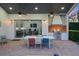 Covered outdoor kitchen and dining area with a built-in grill and a view of the main house at 3382 Fernlake Pl, Longwood, FL 32779