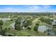Scenic aerial view of a golf course community, featuring a beautiful pond and a cityscape on the horizon at 3514 Golfview Blvd, Orlando, FL 32804