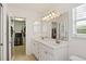 Bright bathroom features a double sink vanity, large mirror, and access to a walk-in closet at 3514 Golfview Blvd, Orlando, FL 32804